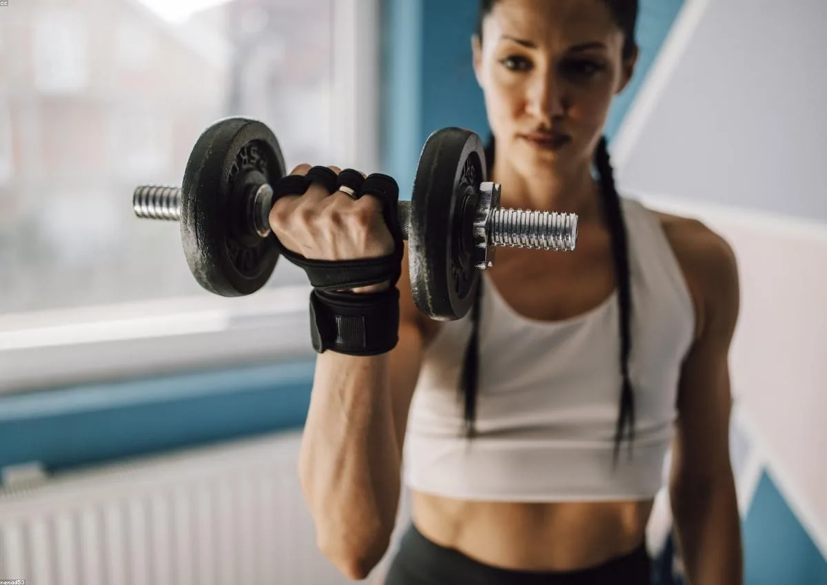Member curling a dumbbell in the gym
