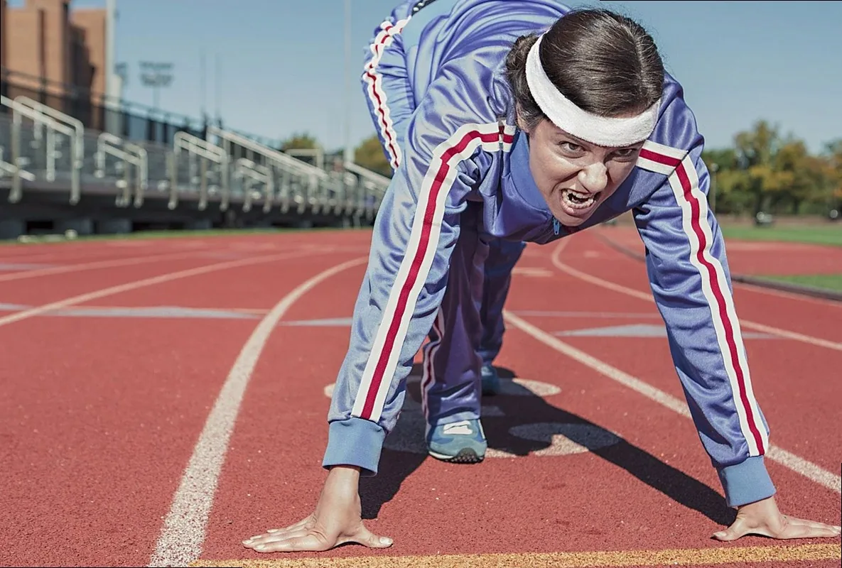 Athlete in a sprint start position on a running track